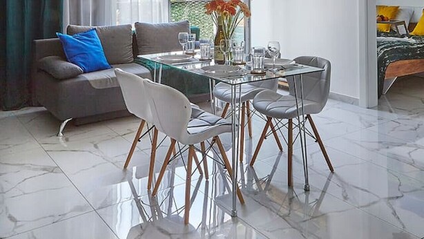 Ein modernes Wohnzimmer mit Essbereich, großen Fenstern und Blick ins Freie.