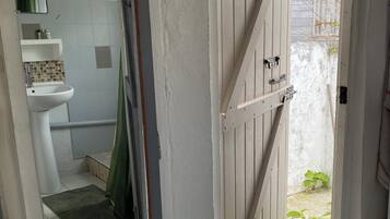 Et badeværelse med en hvid vask, et spejl og en grøn bruseforhæng.