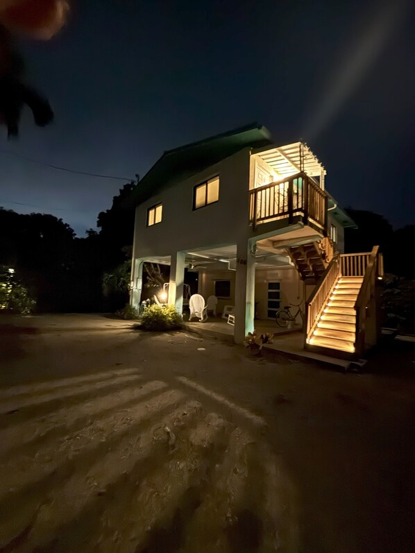 A two-story house with a balcony and a staircase leading to the upper floor.