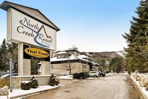 Placa do North Creek Resort com um restaurante de comida tailandesa abaixo.
