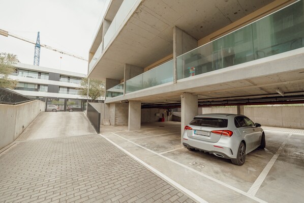 Un parking à plusieurs niveaux, avec une voiture blanche stationnée dans un espace réservé à cet effet.