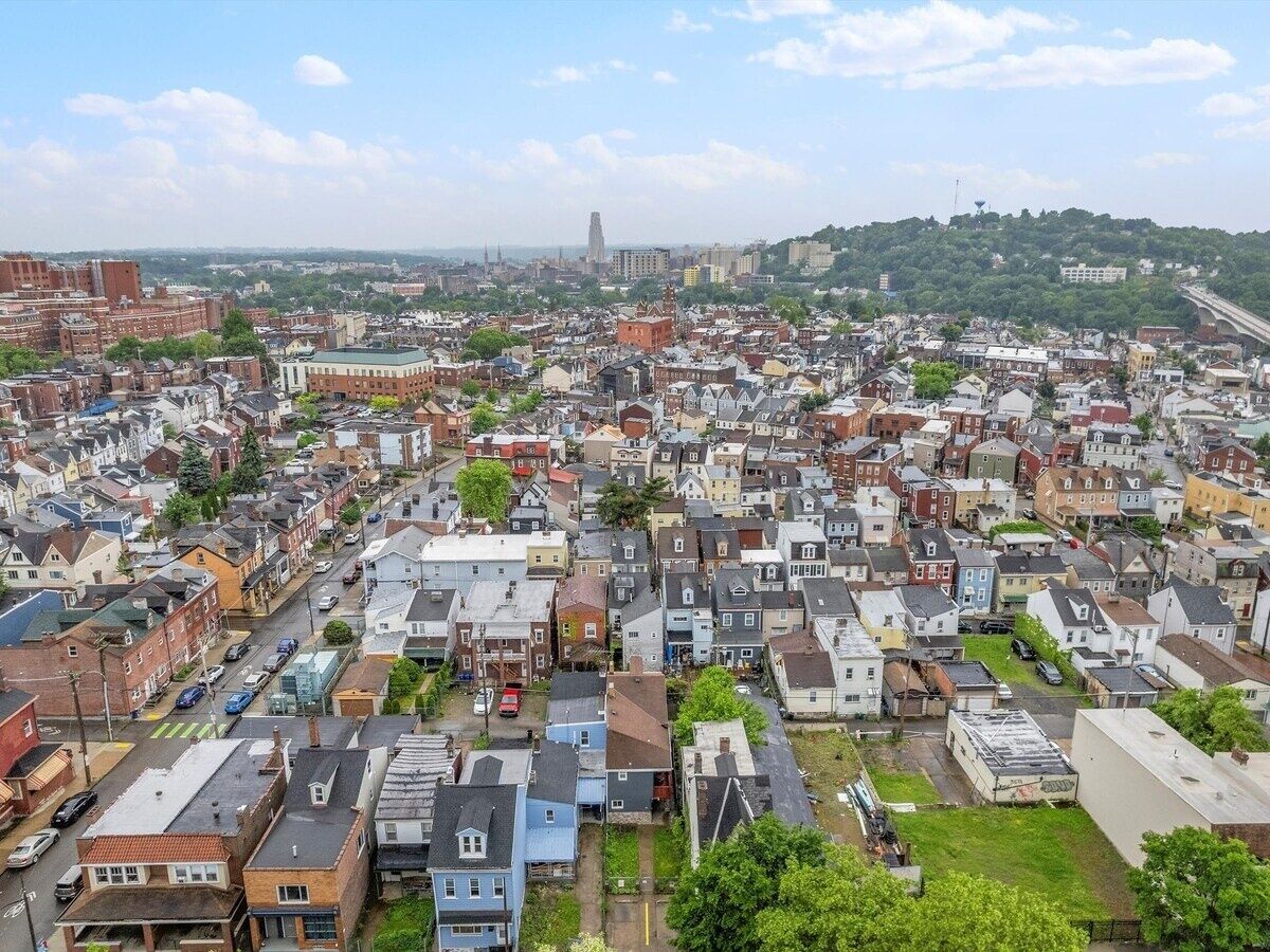 Una zona residencial urbana densamente poblada con diversos estilos de construcción y una colina destacada al fondo.