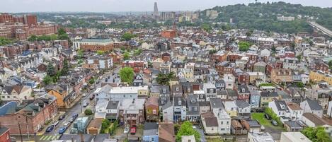 Una zona residencial urbana densamente poblada con diversos estilos de construcción y una colina destacada al fondo.