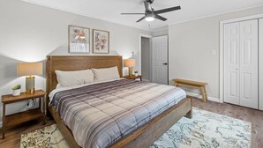 A bedroom with a bed, bedside tables, a ceiling fan, and a door. - Bloomfield, Pittsburgh Large and Accessible 3Bedorom Apartment with Free Parking (Pittsburgh)