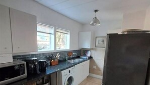 Una cocina compacta con lavadora, microondas y refrigerador.