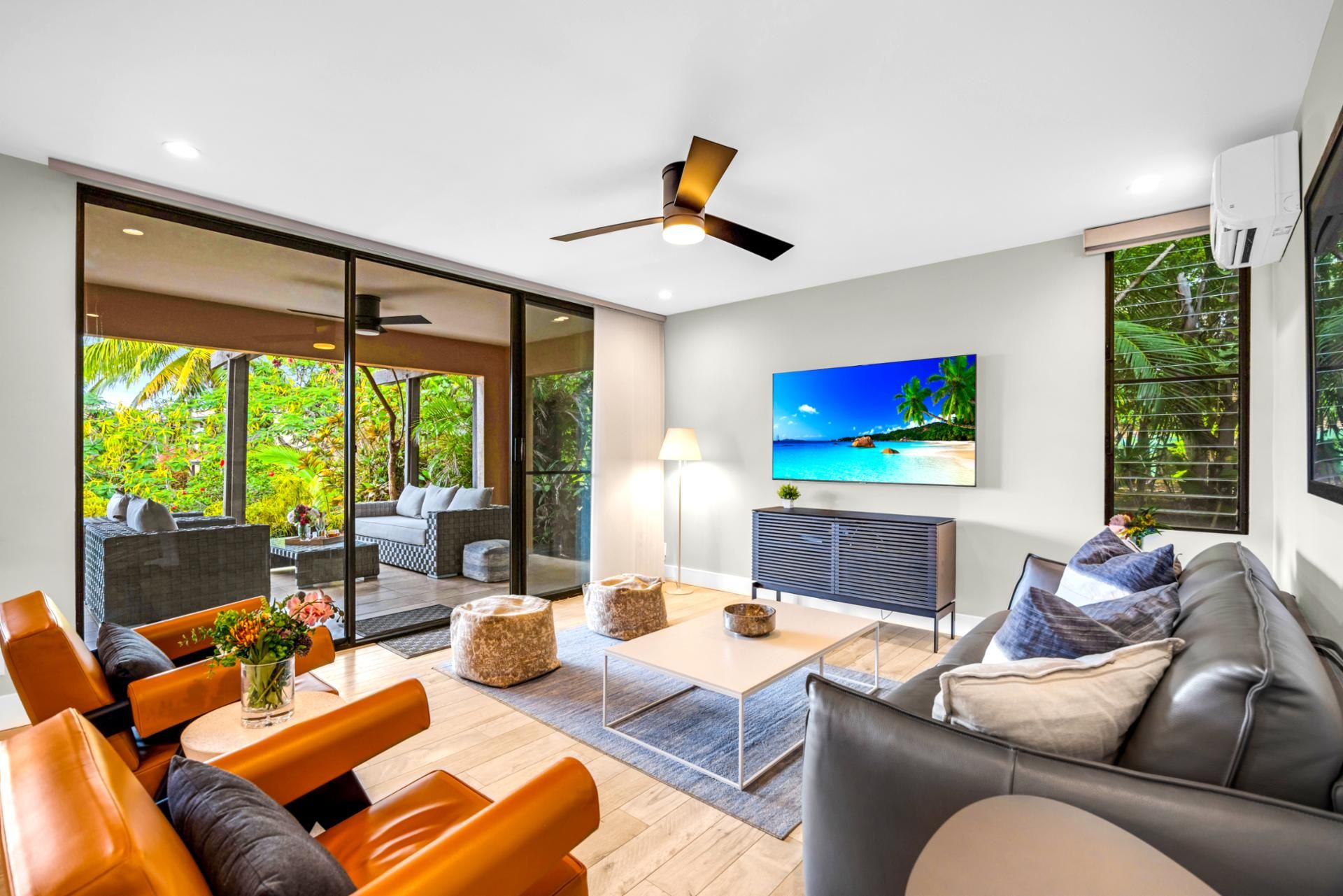 Una sala de estar moderna con un sofá, una mesa de centro y un televisor montado en la pared.