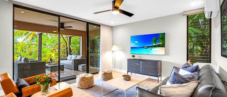 Una sala de estar moderna con un sofá, una mesa de centro y un televisor montado en la pared.