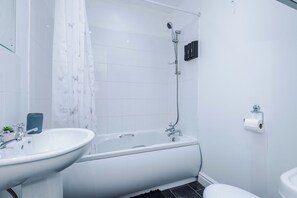 Een haardroger, handdoeken, zeep, toiletpapier
