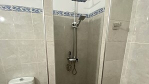 Une salle de bain équipée d’une douche, de toilettes et d’un bidet.