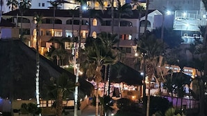 A resort with multiple buildings, palm trees, and a well-lit pathway. - LOCATION LOCATION LOCATION 2 (Cabo San Lucas)