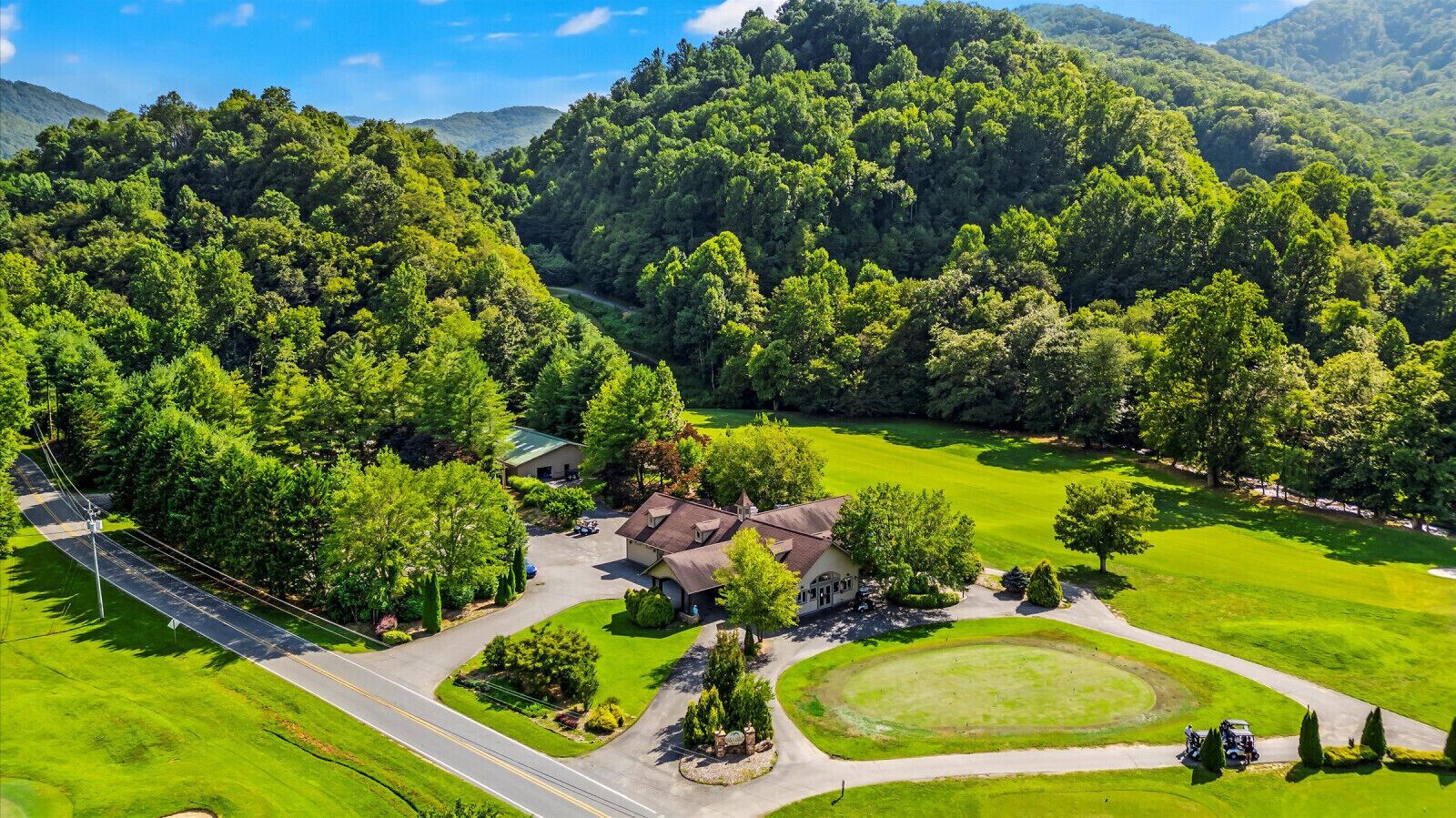 A residential area with a house surrounded by lush greenery and a golf course.