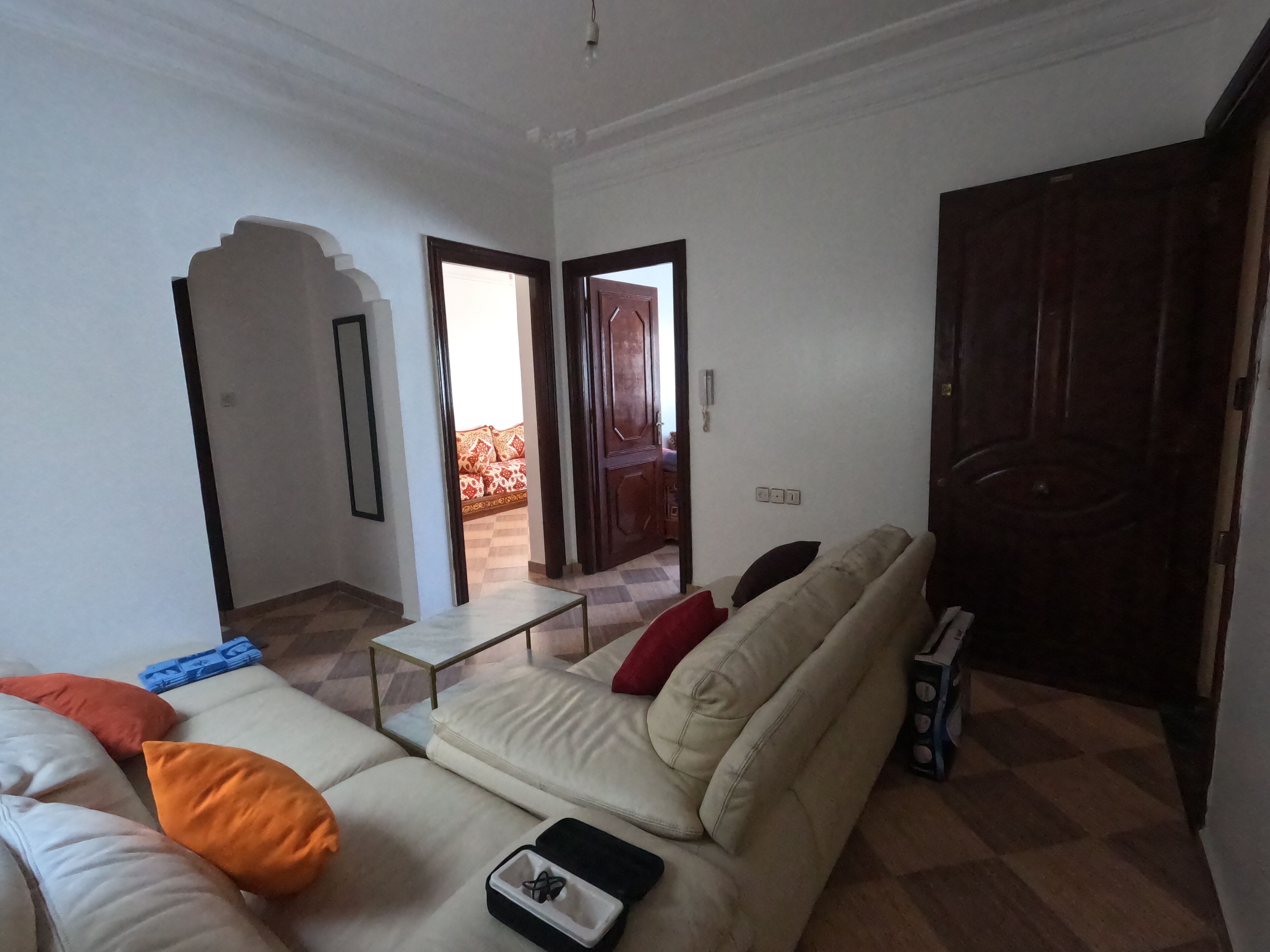 Una sala de estar con un sofá, una mesita y una puerta de madera.