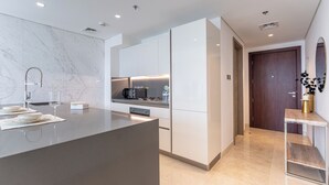 Eine moderne Küche mit Marmor-Spritzschutz, integrierten Geräten und einer zentralen Kücheninsel.