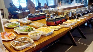 Montaje de bufé con diversos alimentos y una mesa larga.