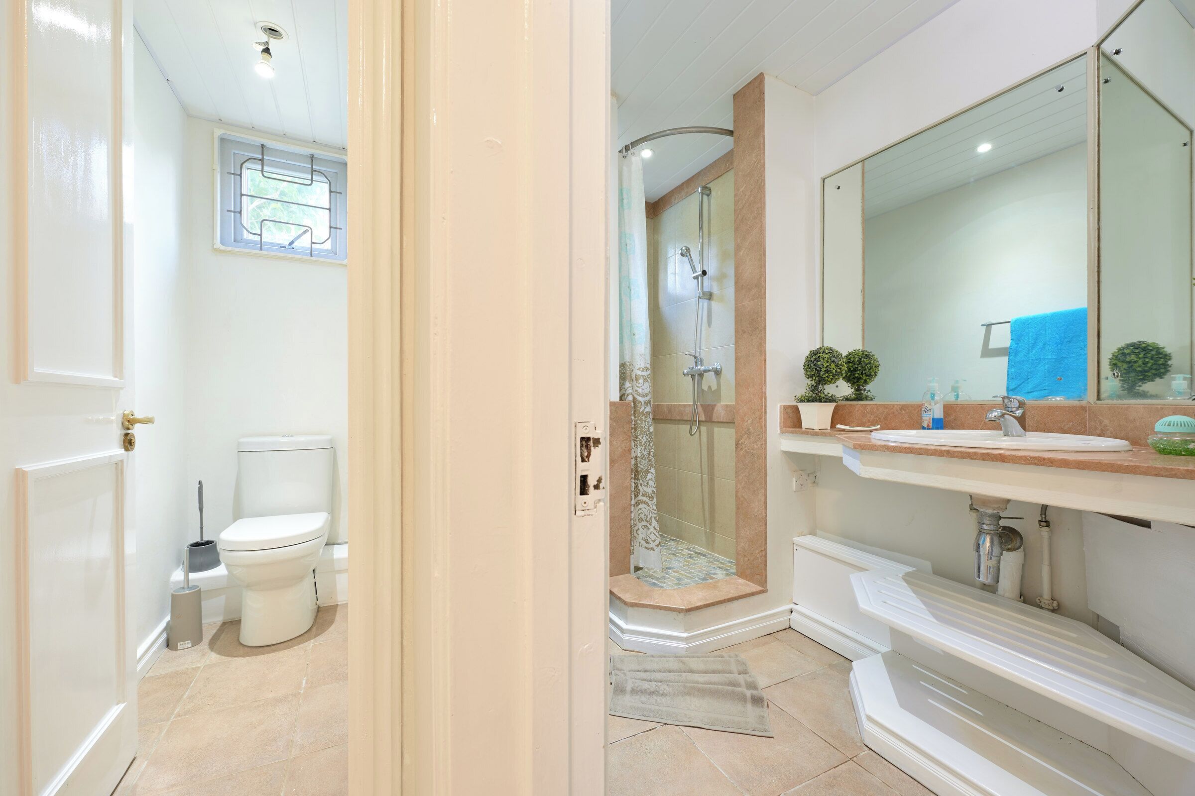 A bathroom with a toilet, shower, and sink.
