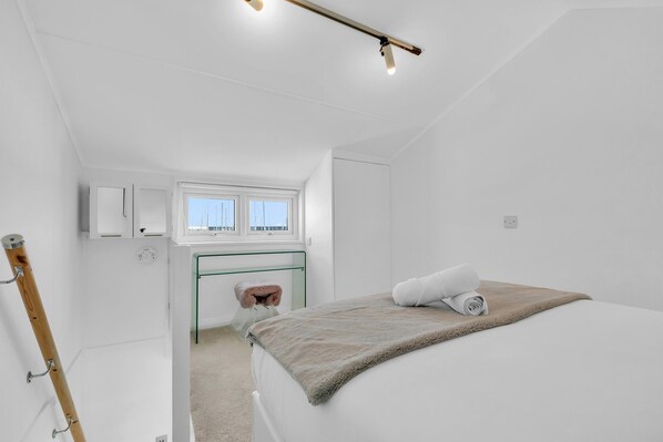 A bedroom with a bed, a window, a desk, and a chair. - On the Water 7 Free Parking By My Getaways (Brighton)