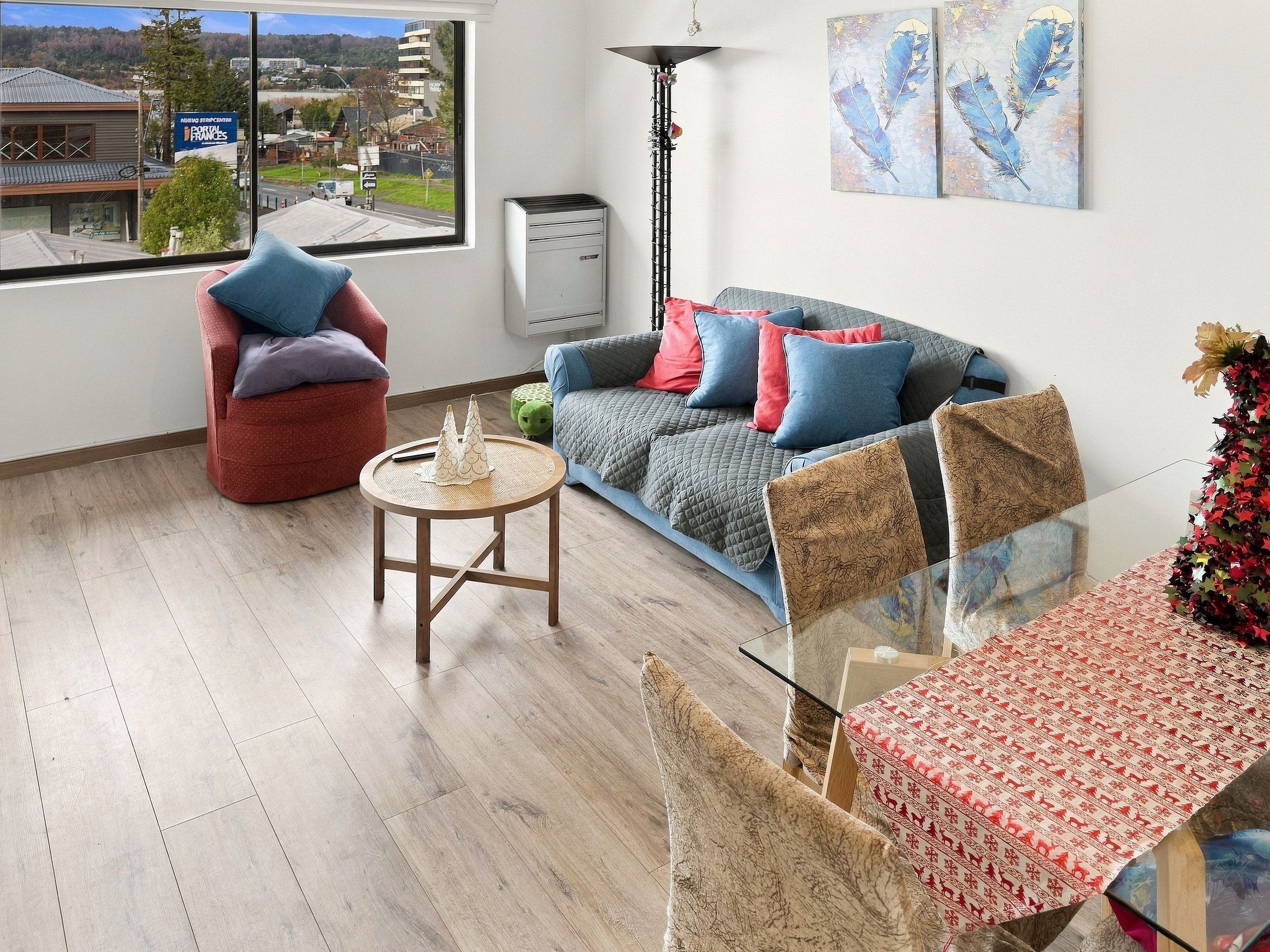 A modern living room with a sofa, armchair, and a glass dining table.