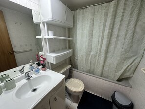 Un baño con inodoro, lavabo y cortina de ducha.