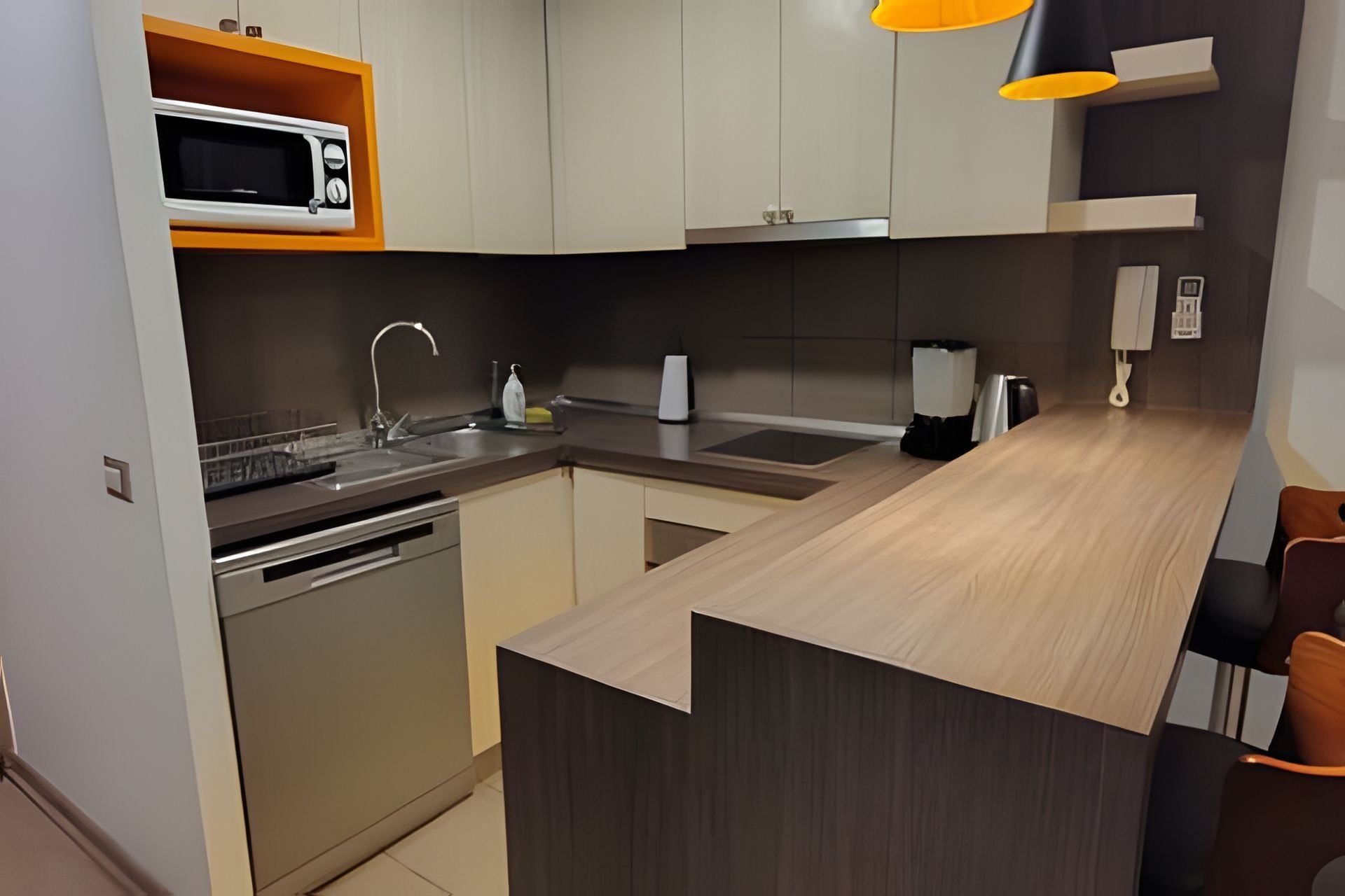 A modern kitchen with a microwave, sink, and coffee maker.