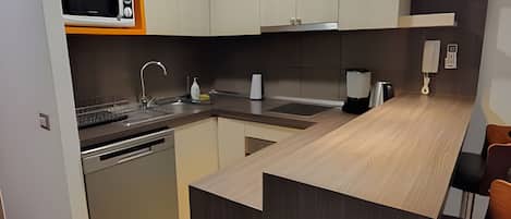 A modern kitchen with a microwave, sink, and coffee maker.