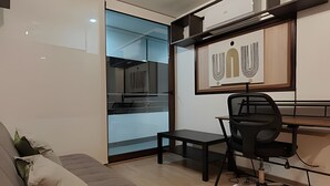 A modern office space with a desk, chair, and a sofa. - Oceana Suites Morandé (Santiago)