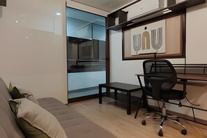 A modern office space with a desk, chair, and a sofa. - Oceana Suites Morandé (Santiago)