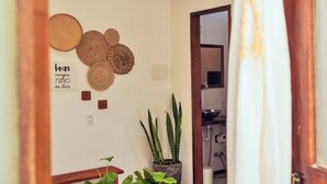 Ein Essbereich mit einem Holztisch, einer hängenden Lampenschirm aus Gewebe und Topfpflanzen.