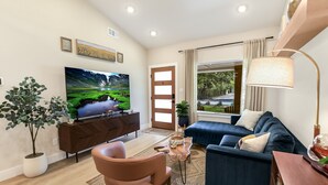 A modern living room with a TV, sofa, and coffee table.