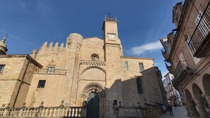 Un edificio histórico con una imponente torre de reloj y una entrada en arco.