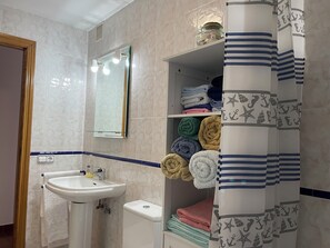 Een haardroger, handdoeken, zeep, toiletpapier