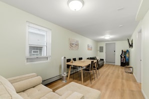 Un espace repas comprenant une table, des chaises et un luminaire au plafond.