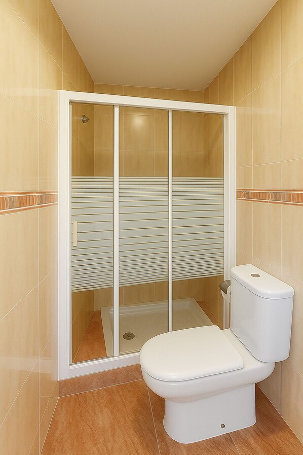 A bathroom with a toilet, a shower enclosure, and tiled walls. - Pension Gelin (Carrizo De La Ribera)