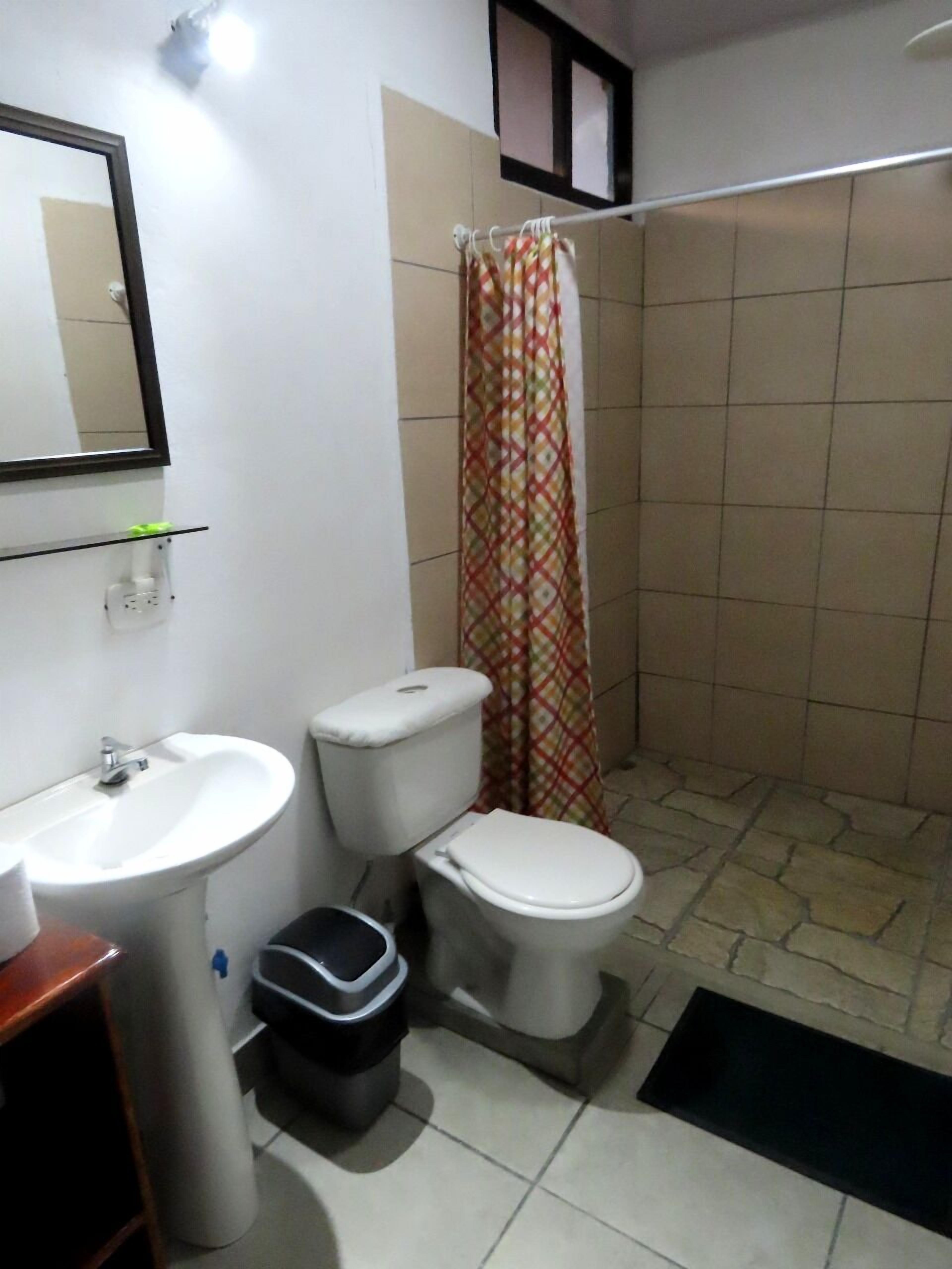 A bathroom with a sink, toilet, and shower curtain.