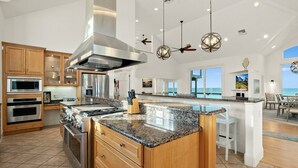 A spacious kitchen with granite countertops, stainless steel appliances, and a large island. - Peaceful Coastal Estate | Beach Access + Sunrises (Palm Coast)