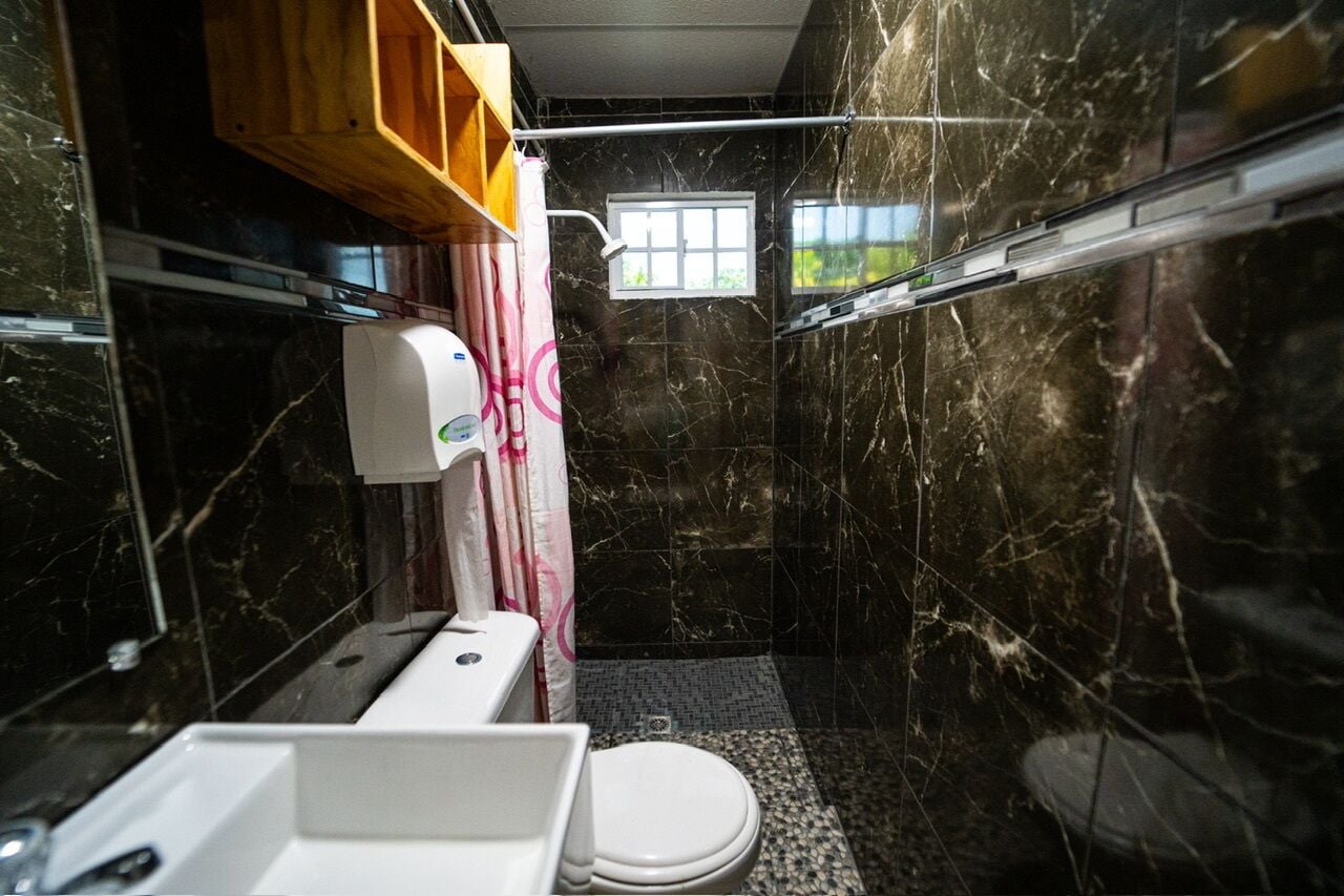 A compact bathroom with a toilet, sink, and shower area.