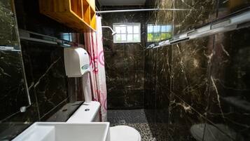 A compact bathroom with a toilet, sink, and shower area.