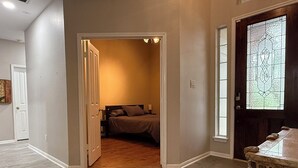 Un dormitorio con una cama, una mesita de noche y una ventana con un diseño de vitral.