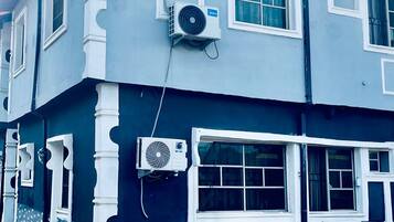 A two-story building with multiple air conditioning units mounted on the exterior walls.