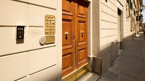 Une entrée d’immeuble dotée d’une double porte en bois, d’un clavier numérique et d’un lecteur de cartes.