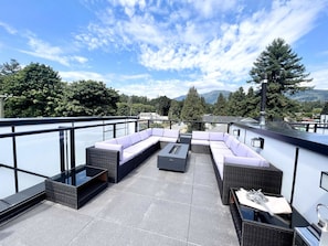 Een terras op het dak met een modulaire bank, een bijzettafeltje en een eettafel.