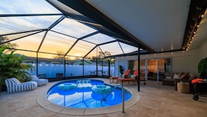 Ein überdachter Außenpool mit Liegestühlen und einer Terrassenfläche.