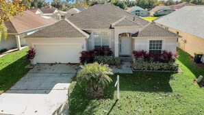 A single-story house with a garage, a front porch, and a well-maintained lawn. - Westridge Super Exclusive 4BR Home Near Disney (Davenport)