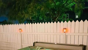Un jacuzzi con valla blanca y luces empotradas.