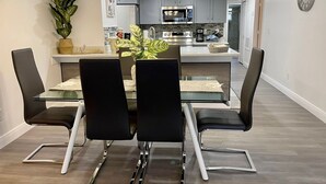 Moderni keittiö, jossa on harmaat kaapit, ruostumattomasta teräksestä valmistetut kodinkoneet ja keskellä sijaitseva keittiösaareke.