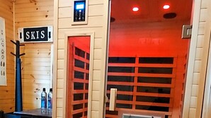 Une pièce avec un plafond en bois, une enseigne indiquant « SKIS », une porte illuminée en rouge et un écran bleu.