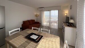 Un espacio habitable compacto con comedor, sofá y kitchenette.