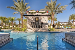 Et poolområde med et skilt der siger "Paradiso Grande" og palmer.