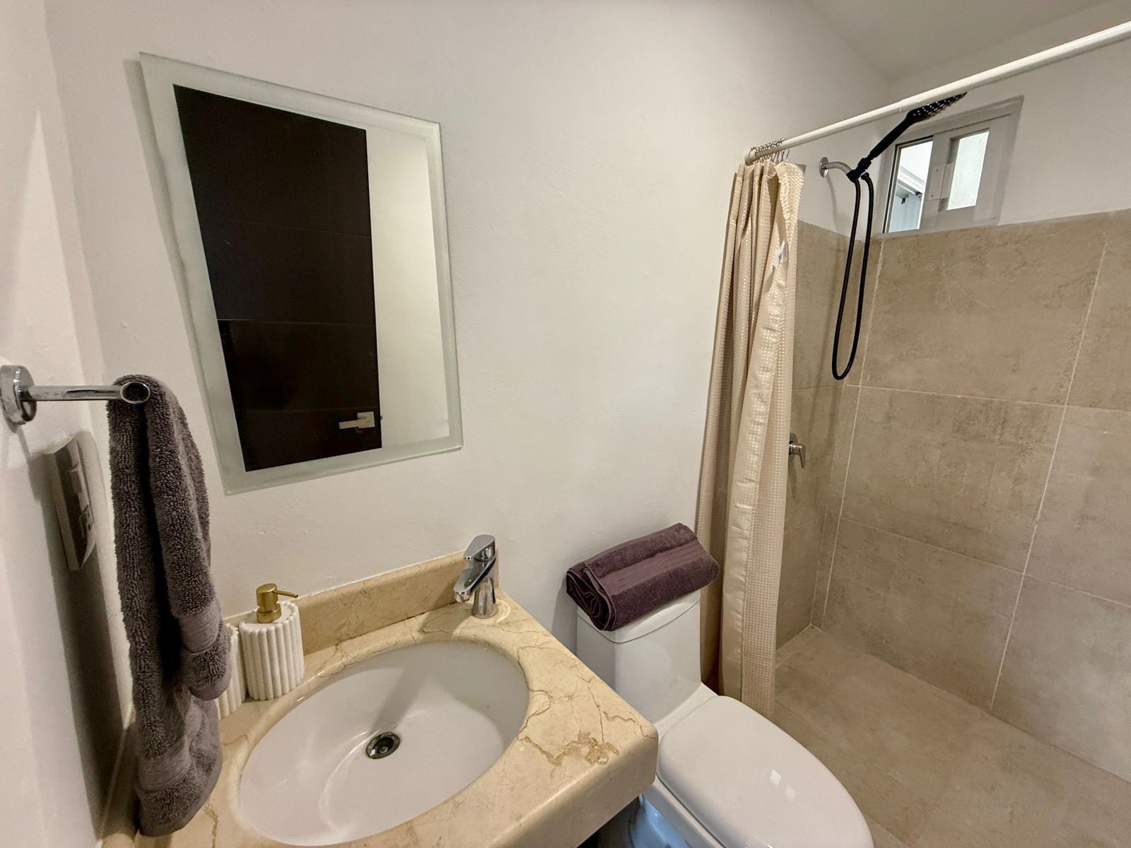 Un baño con lavamanos, inodoro y ducha.