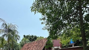 A house with a sloped roof, a small porch, and a grassy yard. - Bungalow hostel Iguazù (Puerto Iguazú)