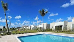 A rectangular swimming pool with clear blue water, surrounded by a tiled deck.
